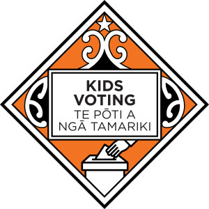 The Kids Voting - Te Pōti a Ngā Tamariki logo - a diamond shape featuring a koru design and a hand placing a vote into a ballot box, with the name of the programme in English and Te Reo in the centre.