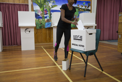 A woman in a school hall on election day, putting her voting paper in a box marked ‘special votes’.